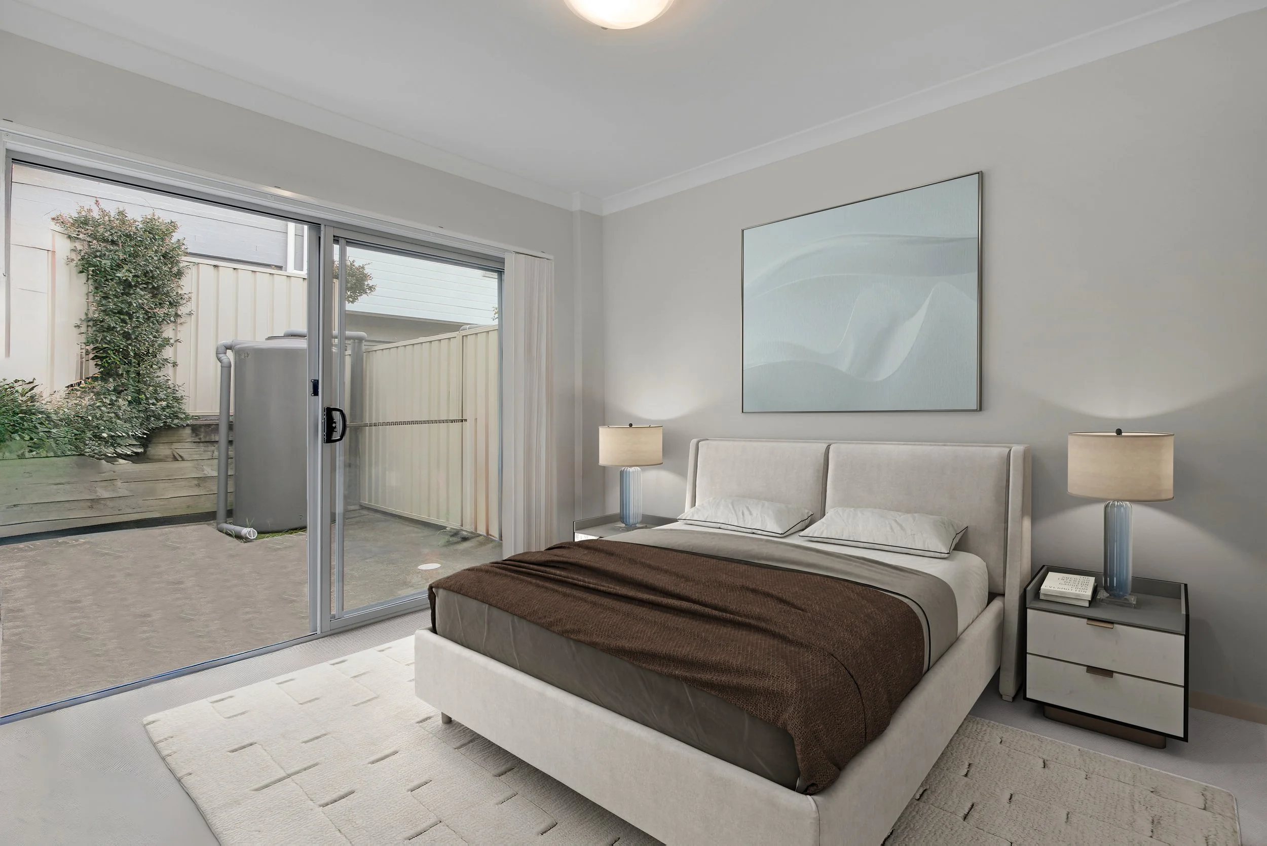 Bedroom with a white bed, two bedside lamps, glass sliding door leading to a backyard with a pond, beige carpet, and minimal decor.