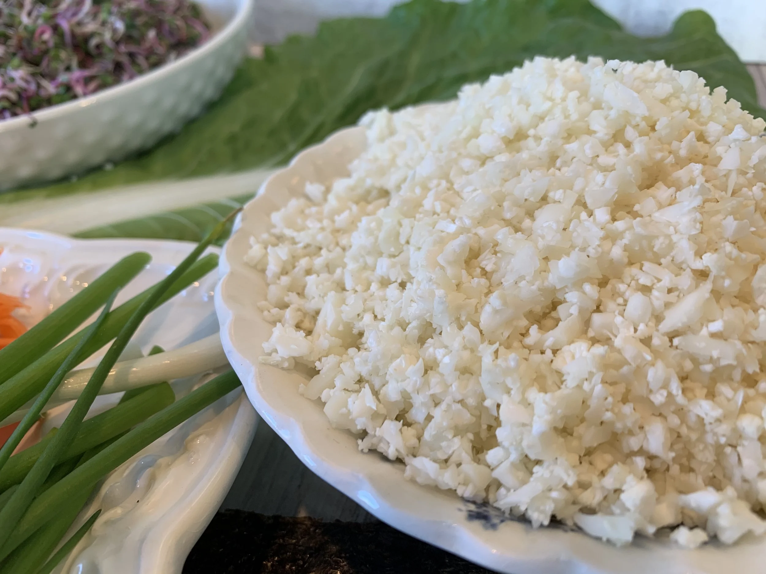 Fresh raw cauliflower rice prepared as an optional filling for vegan sushi rolls.