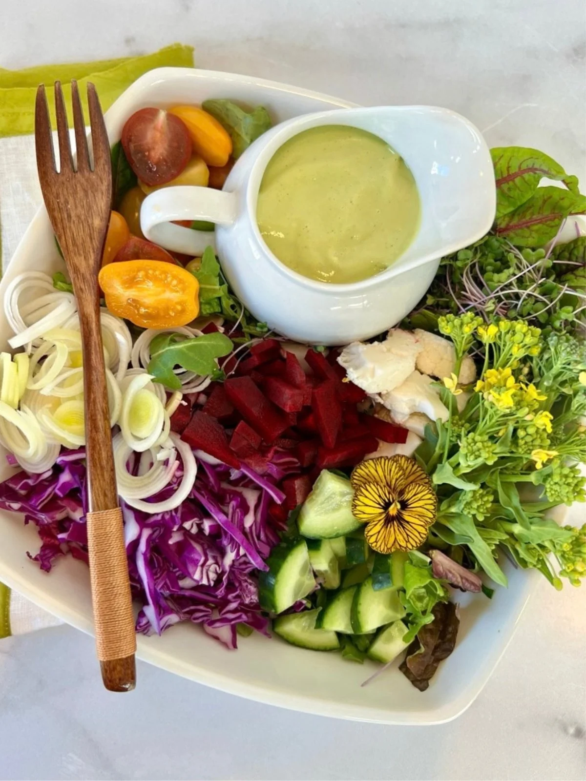 Colorful raw vegetable salad with cabbage, greens, cucumber, tomatoes, sprouts, and creamy dressing for Dr. Brooke Goldner's Goodbye Autoimmine Protocol.