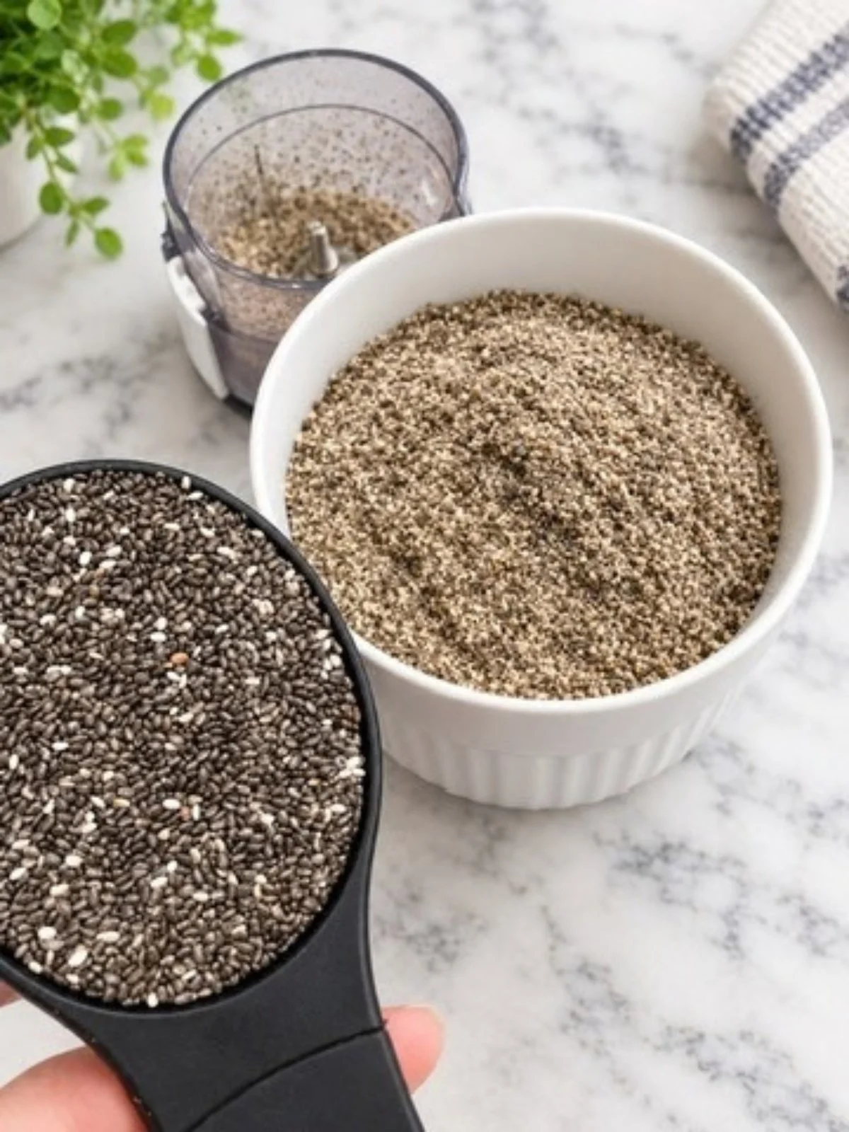 Whole chia seeds beside freshly ground chia on a marble countertop