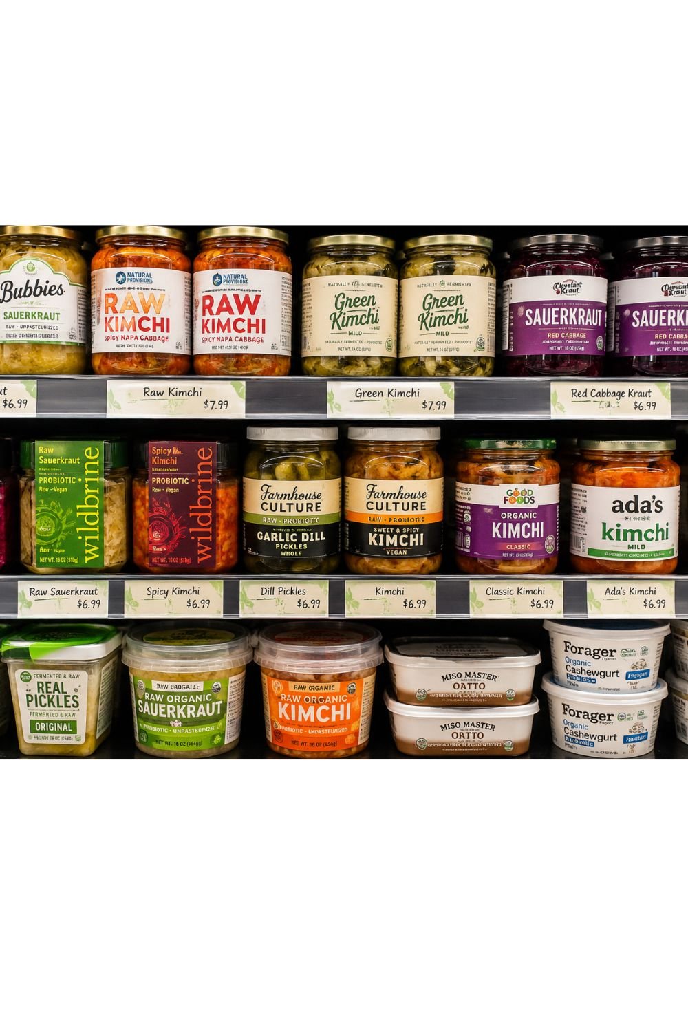 Refrigerated grocery store shelf with sauerkraut, kimchi, pickles, and other fermented foods.