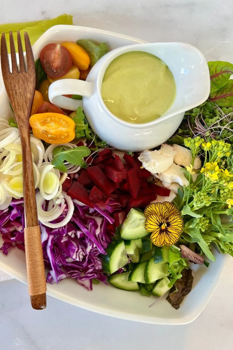Colorful raw salad with purple cabbage, broccoli sprouts, cucumber, greens and other vegetables.