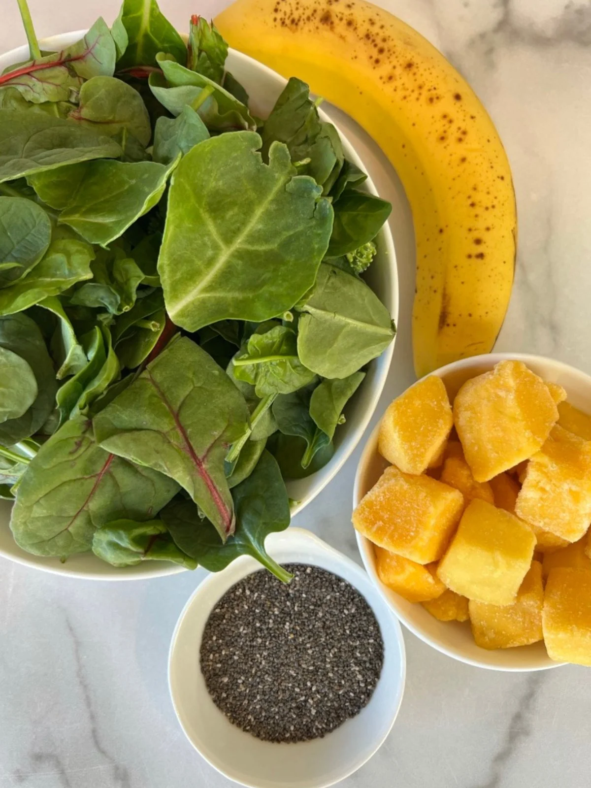 Spinach, ripe banana, frozen mango, and chia seeds prepared for a Hyper-Nourishing smoothie