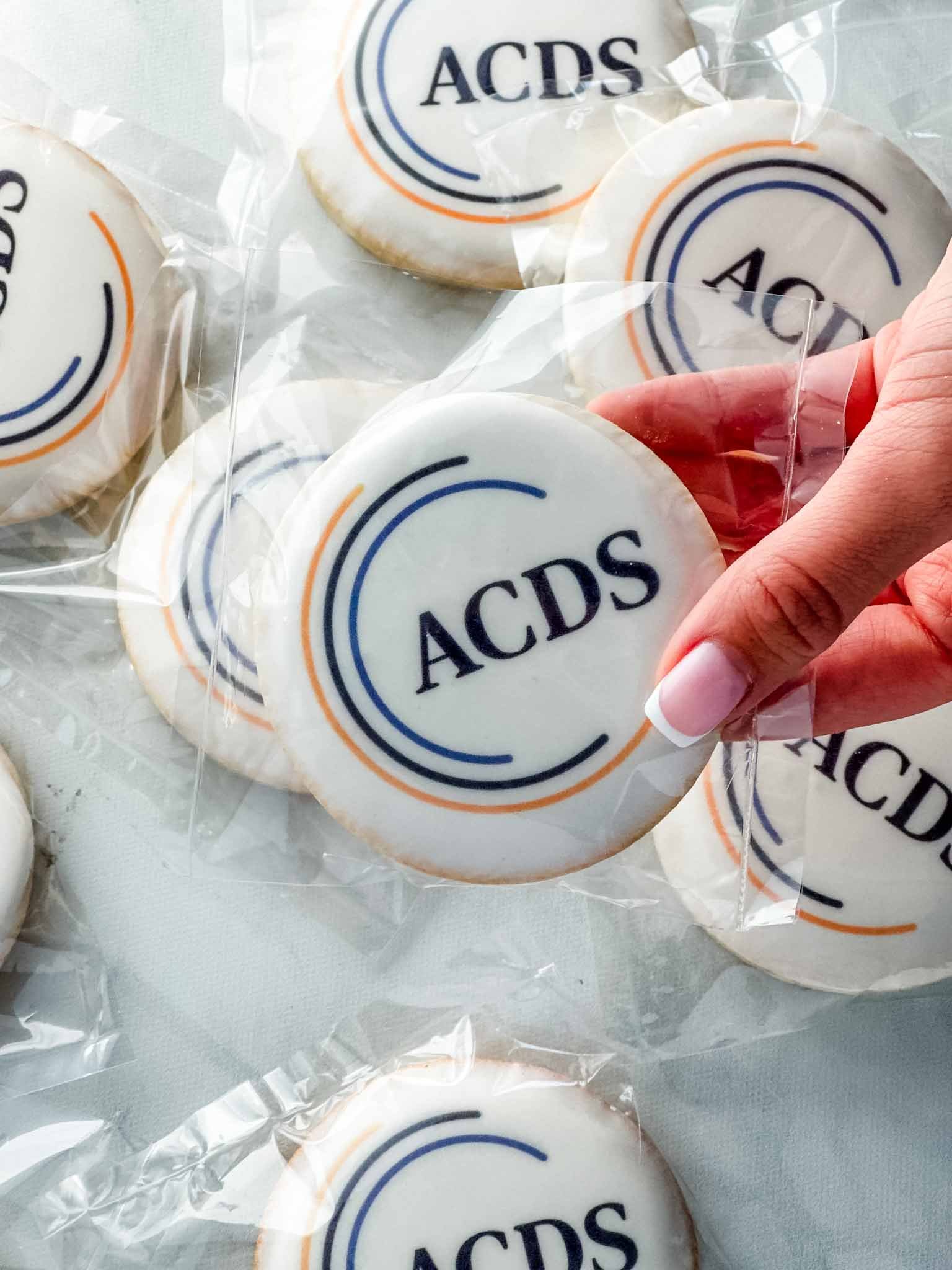 A Worthy Cookie hand holding round logo sugar cookies individually bagged.jpg