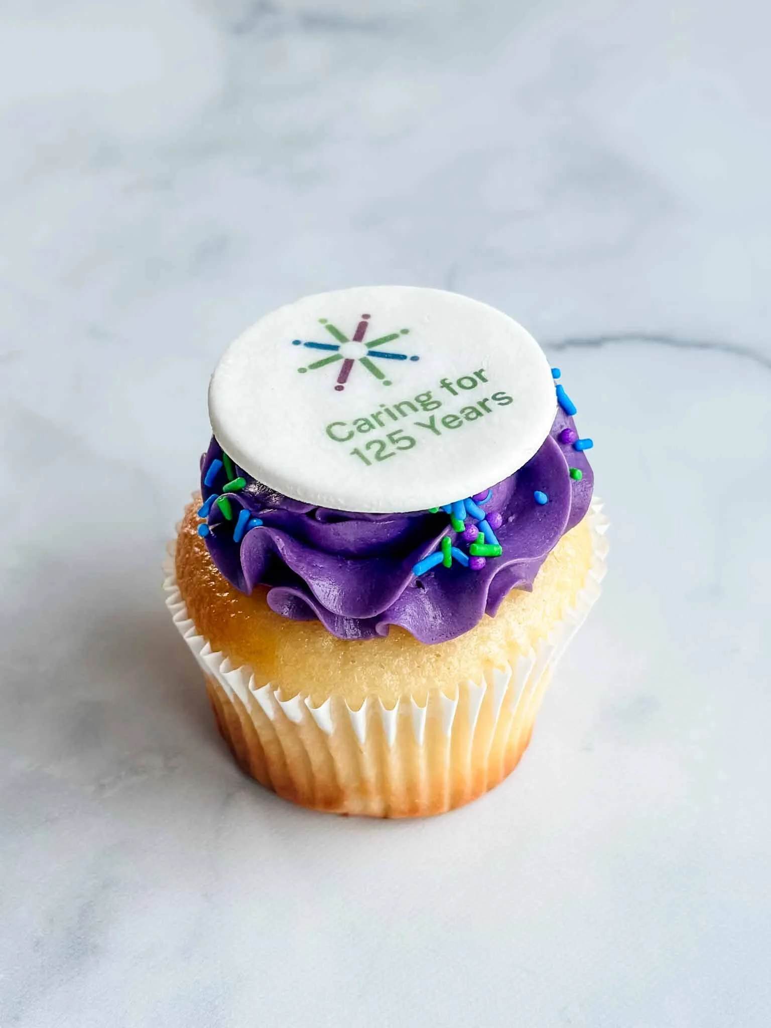 A Worthy Cookie Custom Purple Buttercream cupcake with logo image.jpg