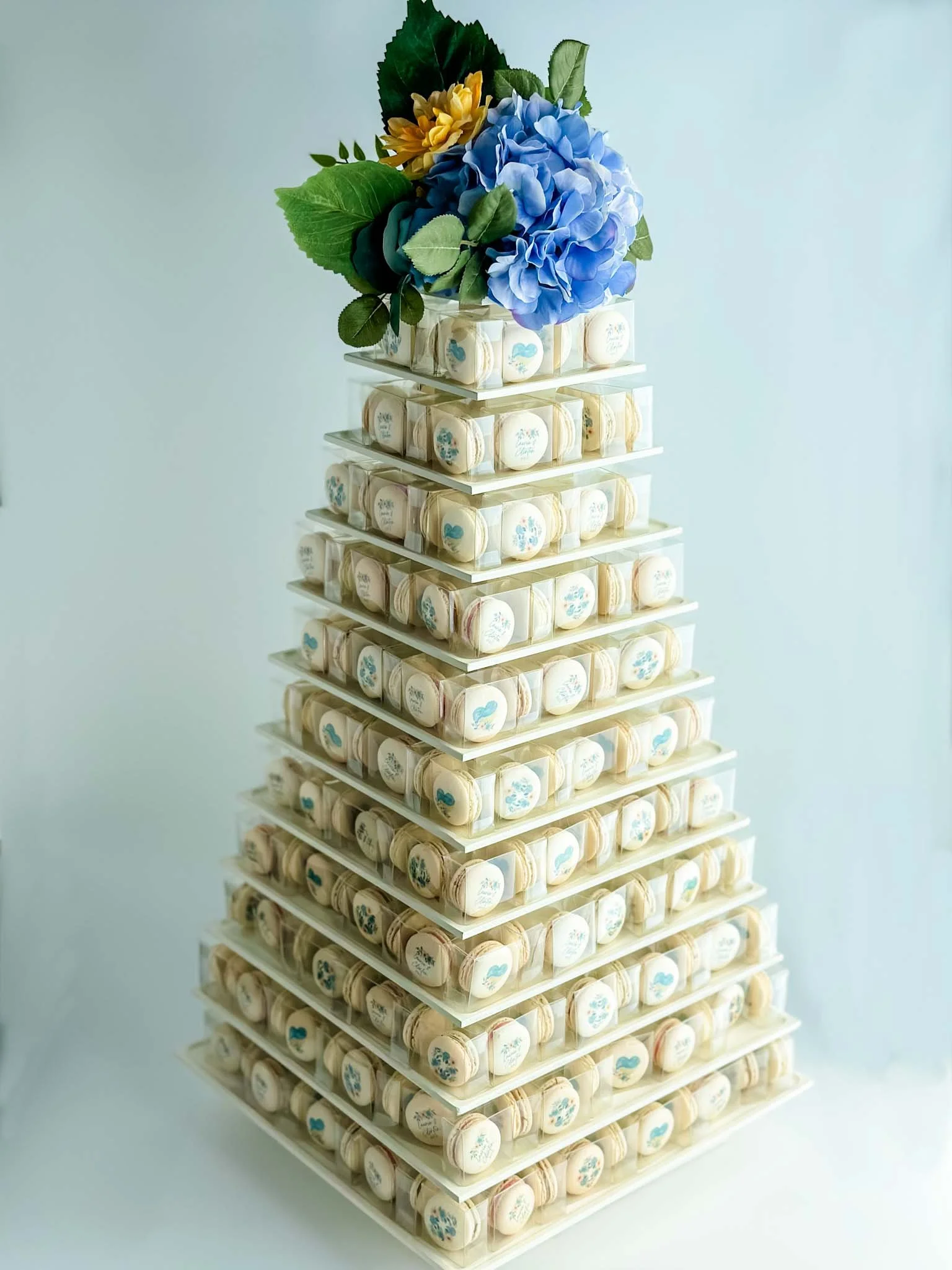 A Worthy Cookie wedding macaron tower with blue and yellow flower topper.jpg