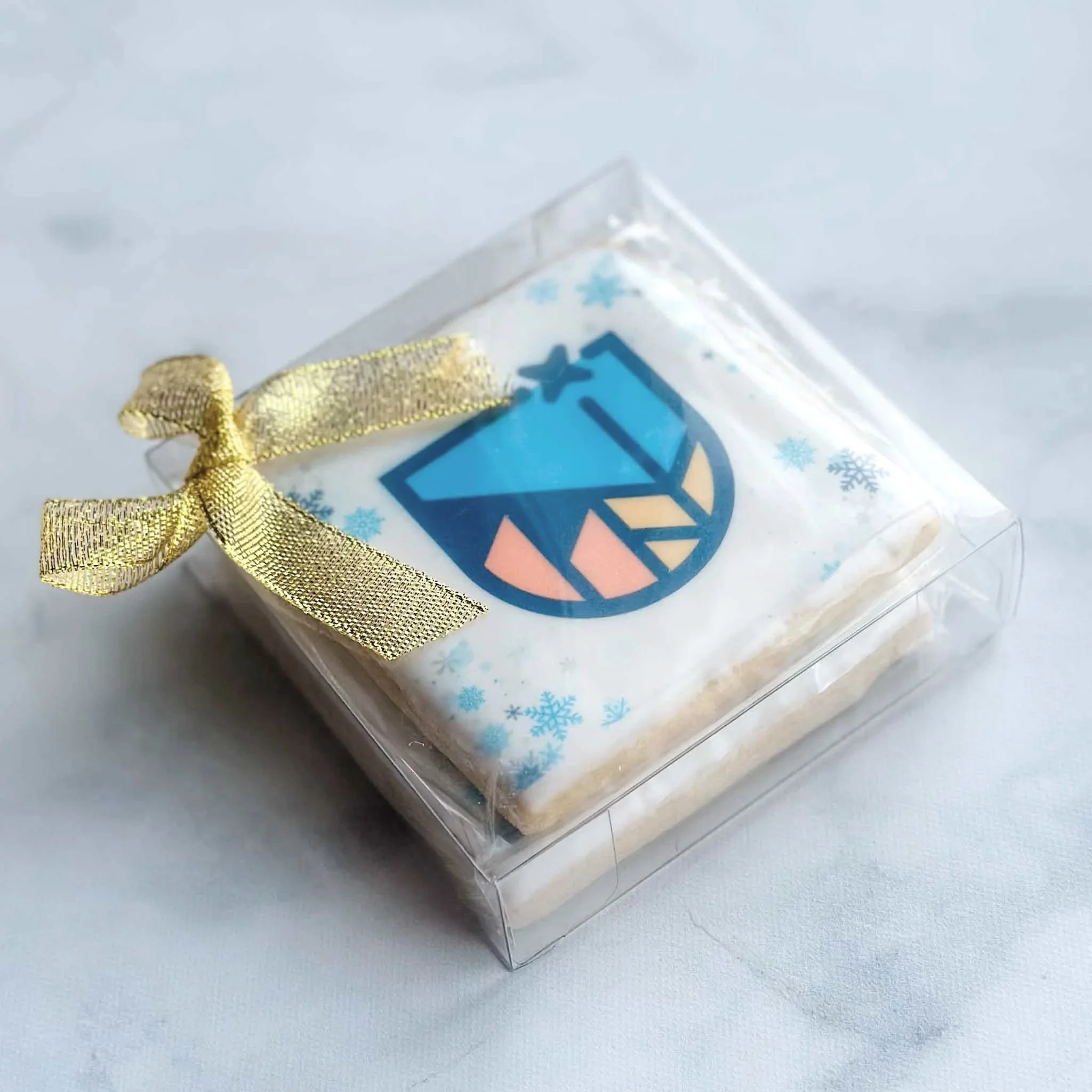 Boxed branded holiday sugar cookie with company logo and gold gift bow
