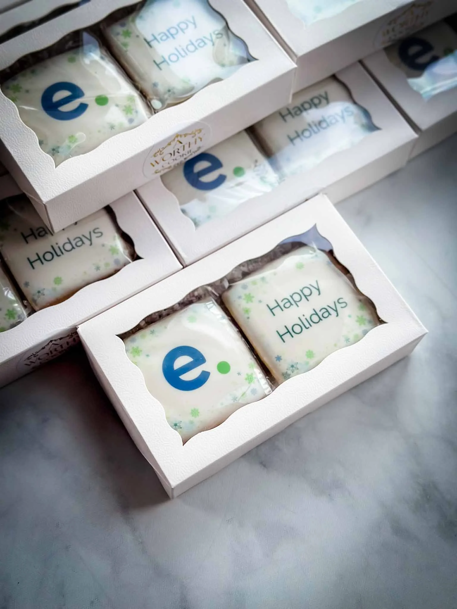 Boxed corporate holiday cookie gifts with company logo and Happy Holidays message