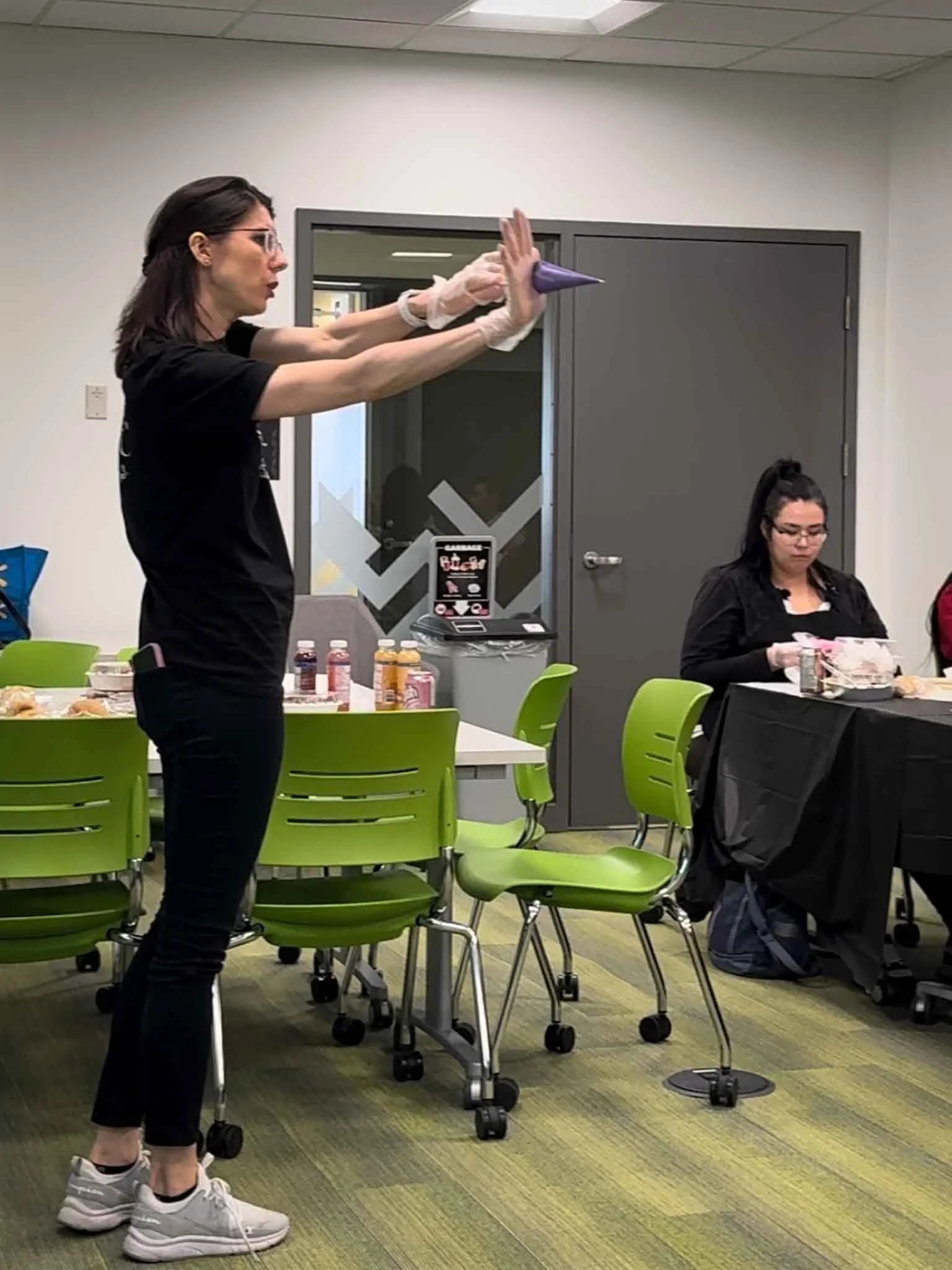 A Worthy Cookie Sugar Cookie decorting class maria demonstrating how to hold a piping bag.jpg