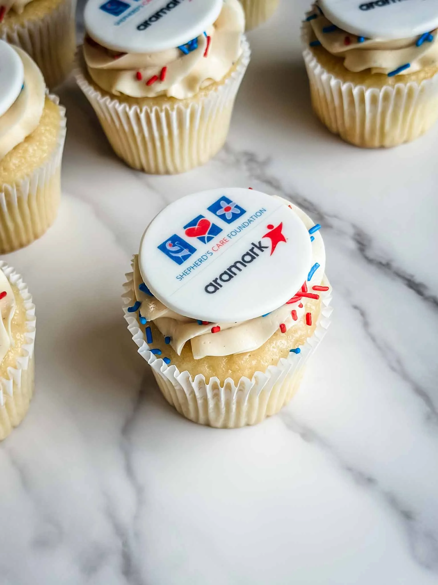 A Worthy Cookie branded vanilla cupcakes with printed with two logos.jpg