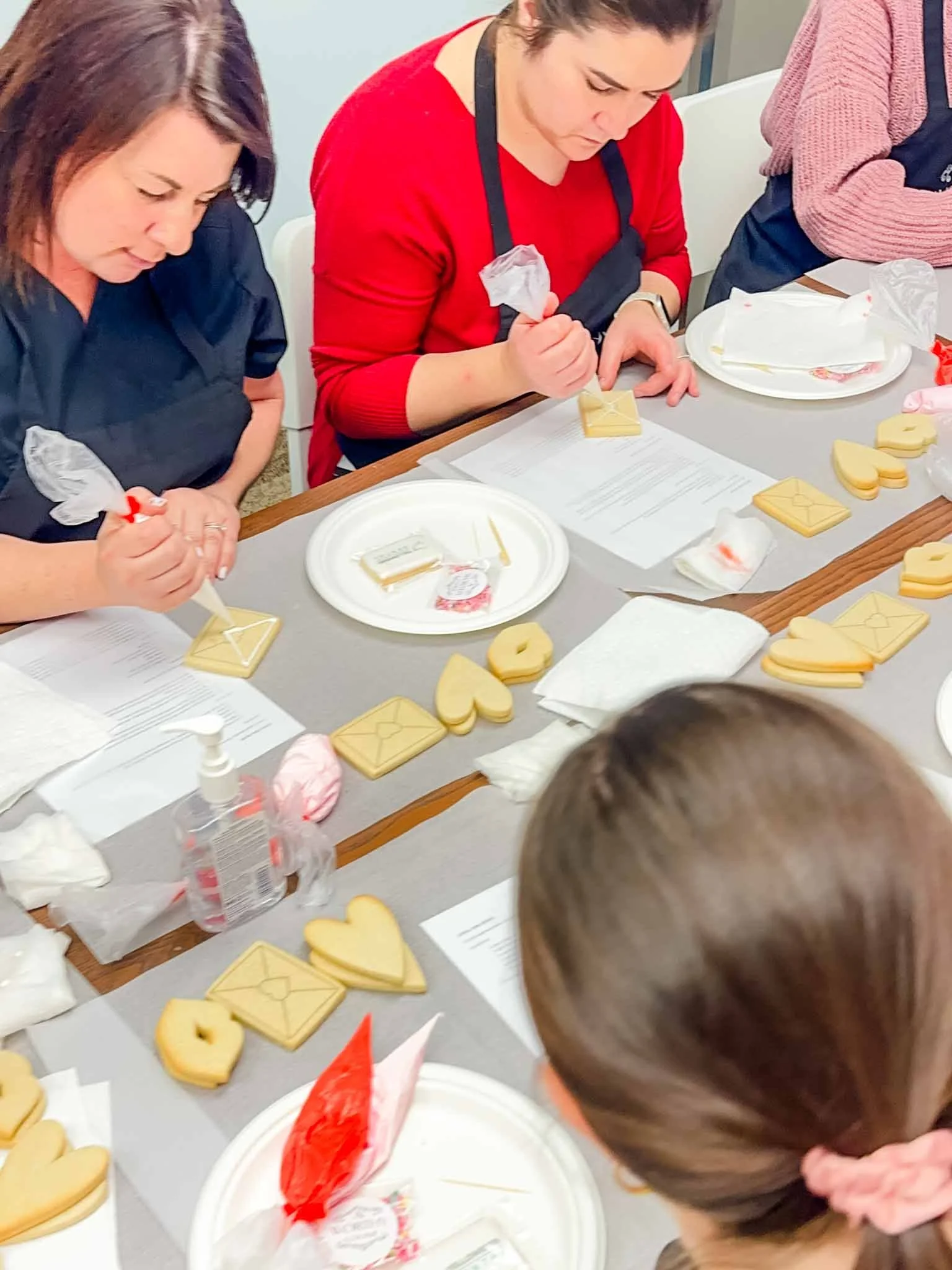 Small work team decorating sugar cookies together during a staff appreciation activity