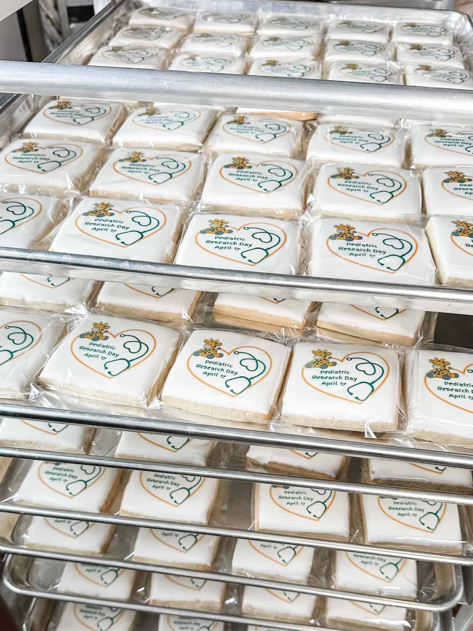 High-volume corporate sugar cookie order prepared on bakery production racks
