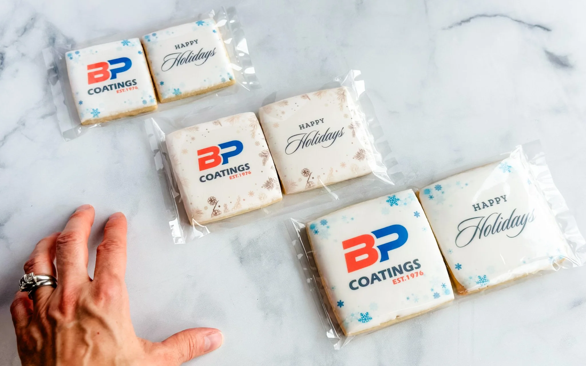 BP Coatings branded holiday sugar cookies with company logo and festive holiday messages