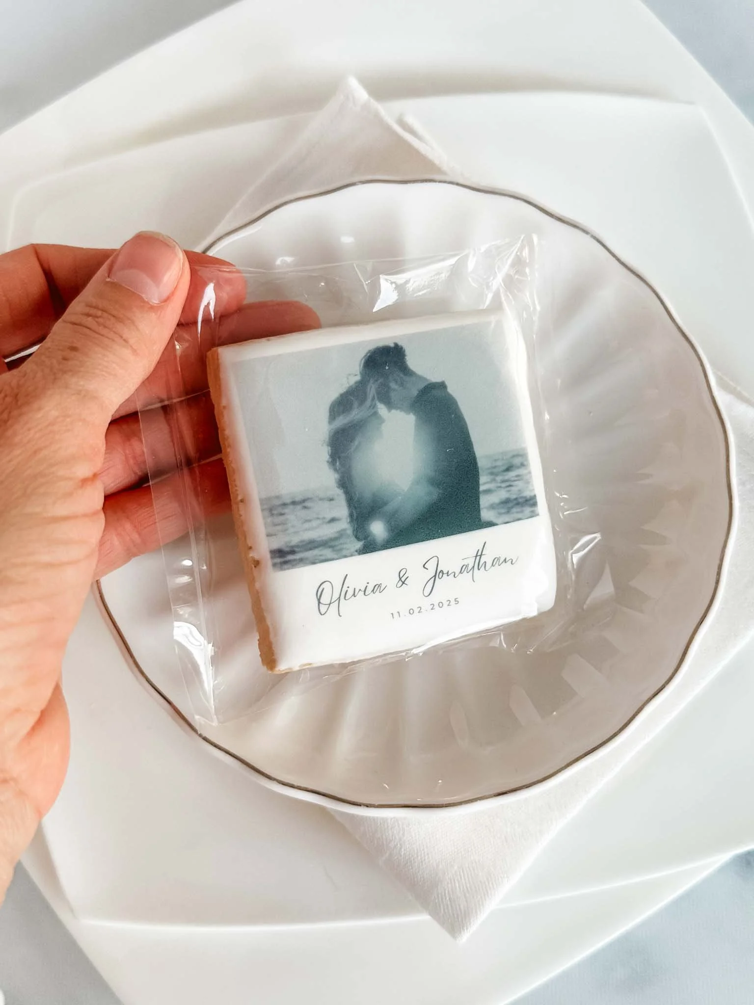 A Worthy Cookie square shaped XL wedding names and black and white romantic photo on top of plate setting.jpg