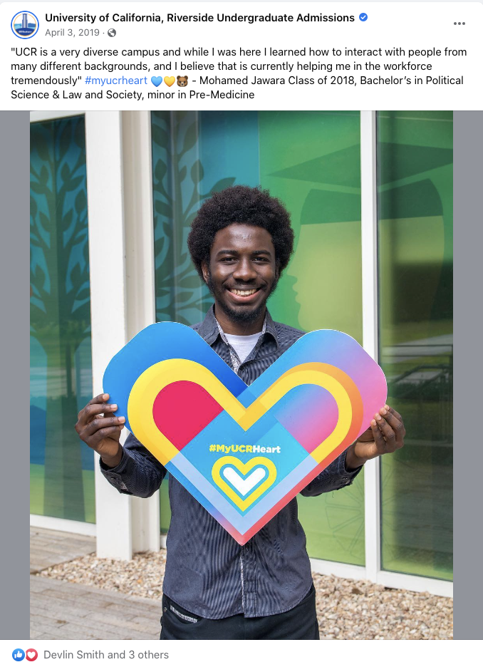  An alumnus holds up a paper heart. 