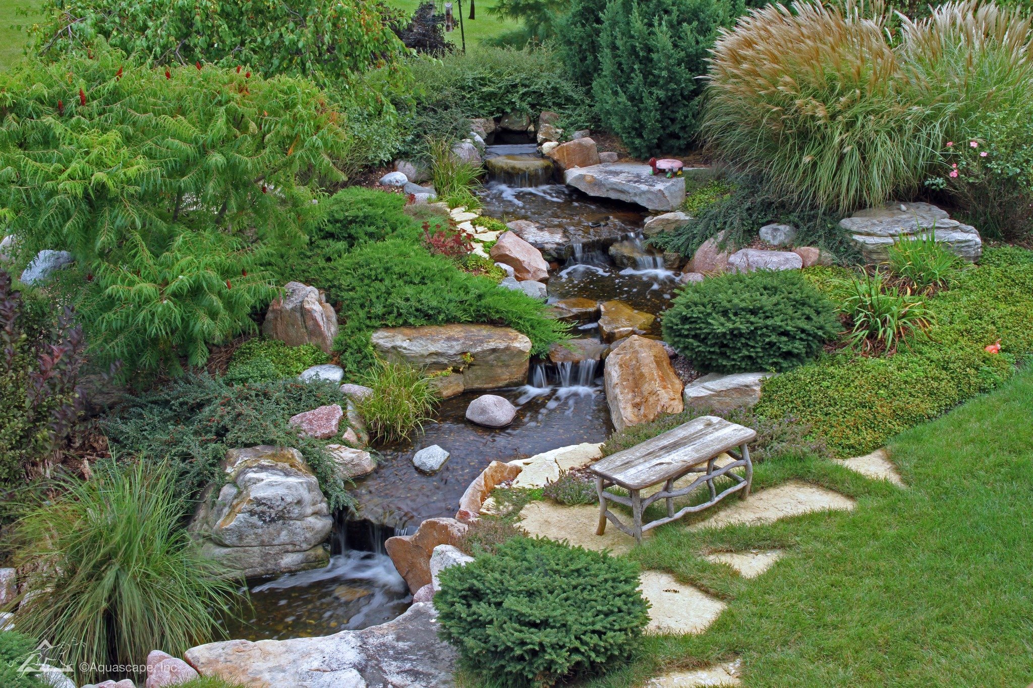 A front yard should make people slow down - whether you want to draw in friends, bring a smile to everyone who passes by, or update your curb appeal to get top dollar on a sale. 

A pondless waterfall does exactly that.

It creates movement, sound, a