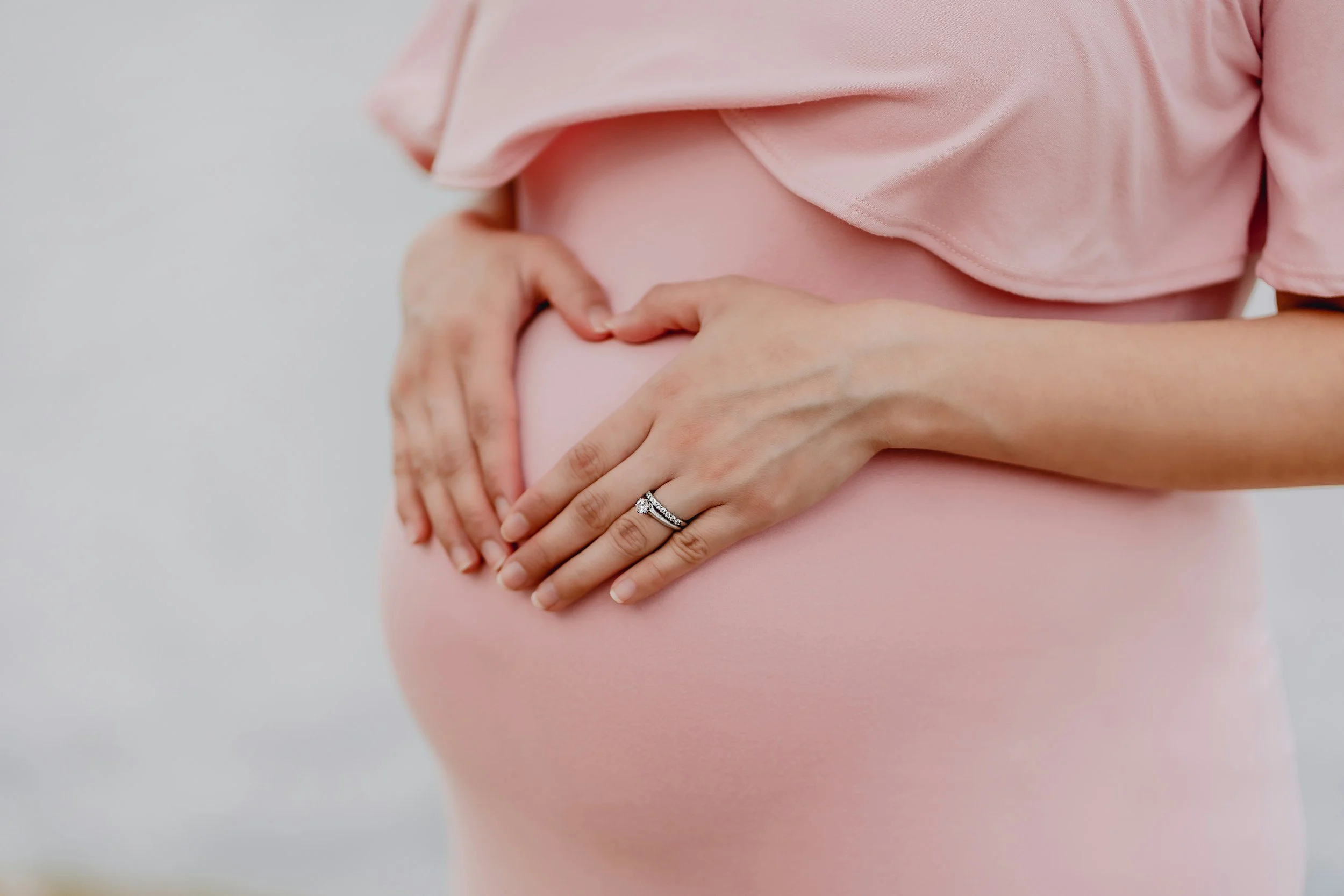 Pregnant woman supporting her lower back due to pregnancy-related pain.