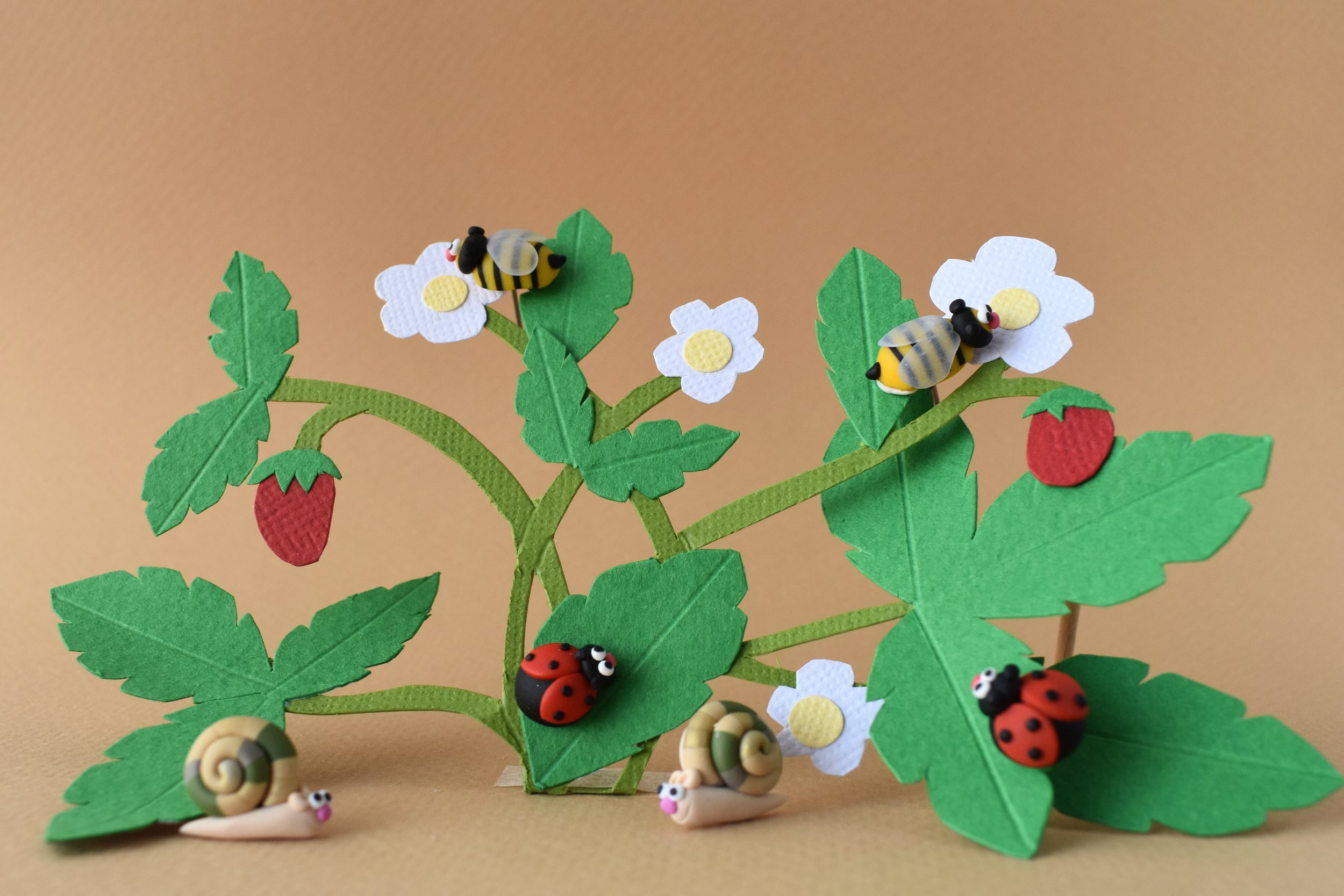 A paper strawberry plant populated by snails, bees and ladybugs!