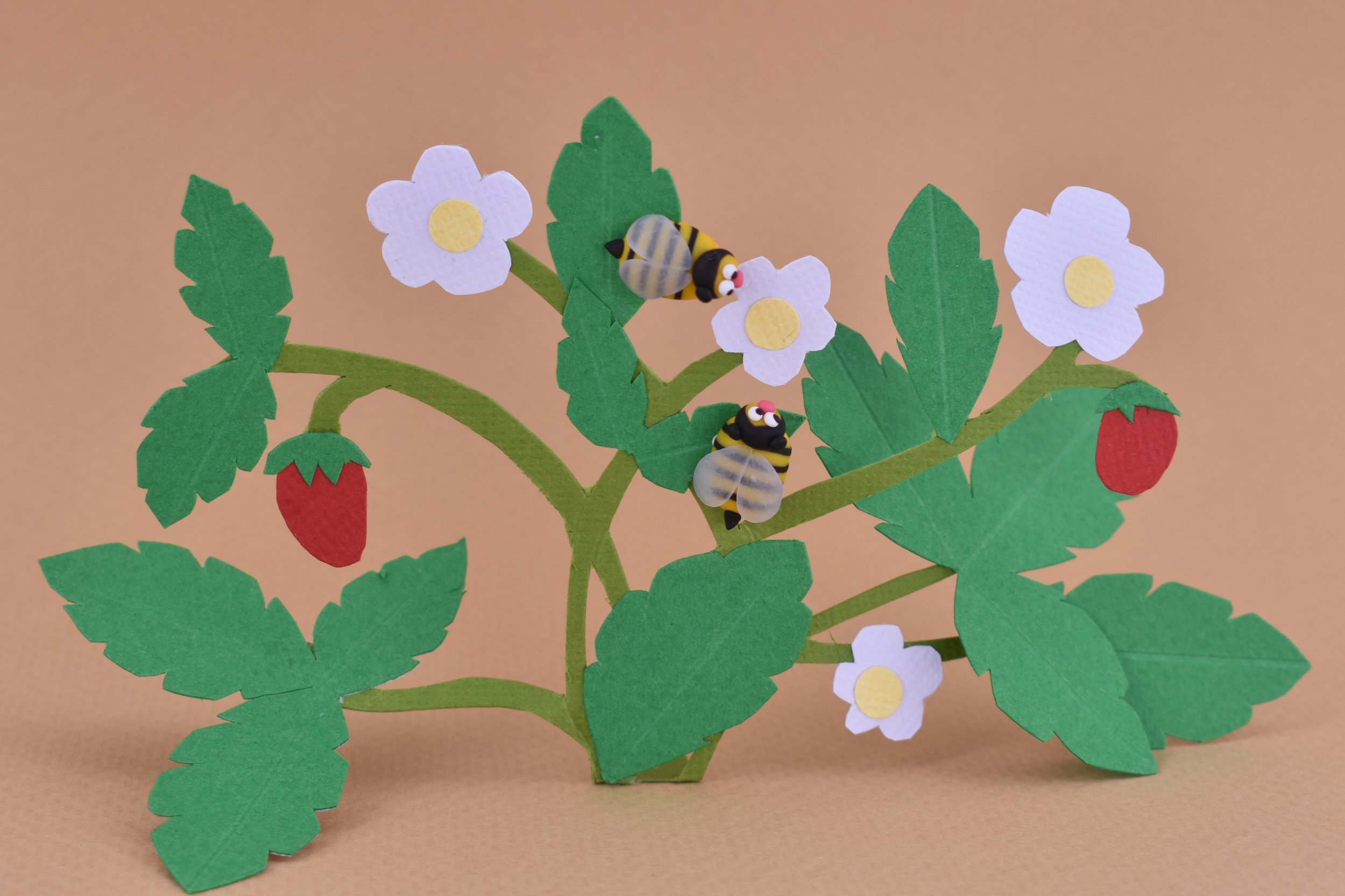 Bee earrings collecting magic pollen from strawberry flowers.