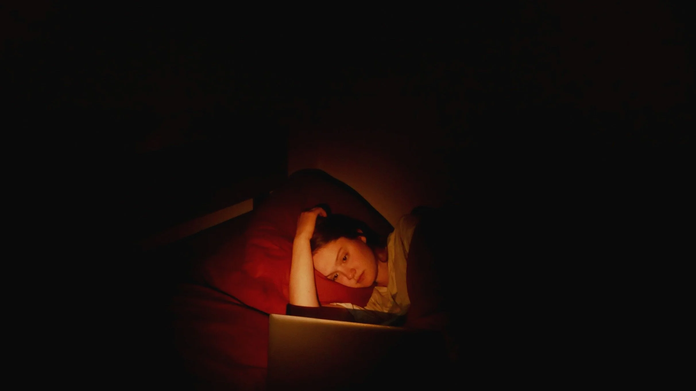 Carly Geary laying in a red bed.