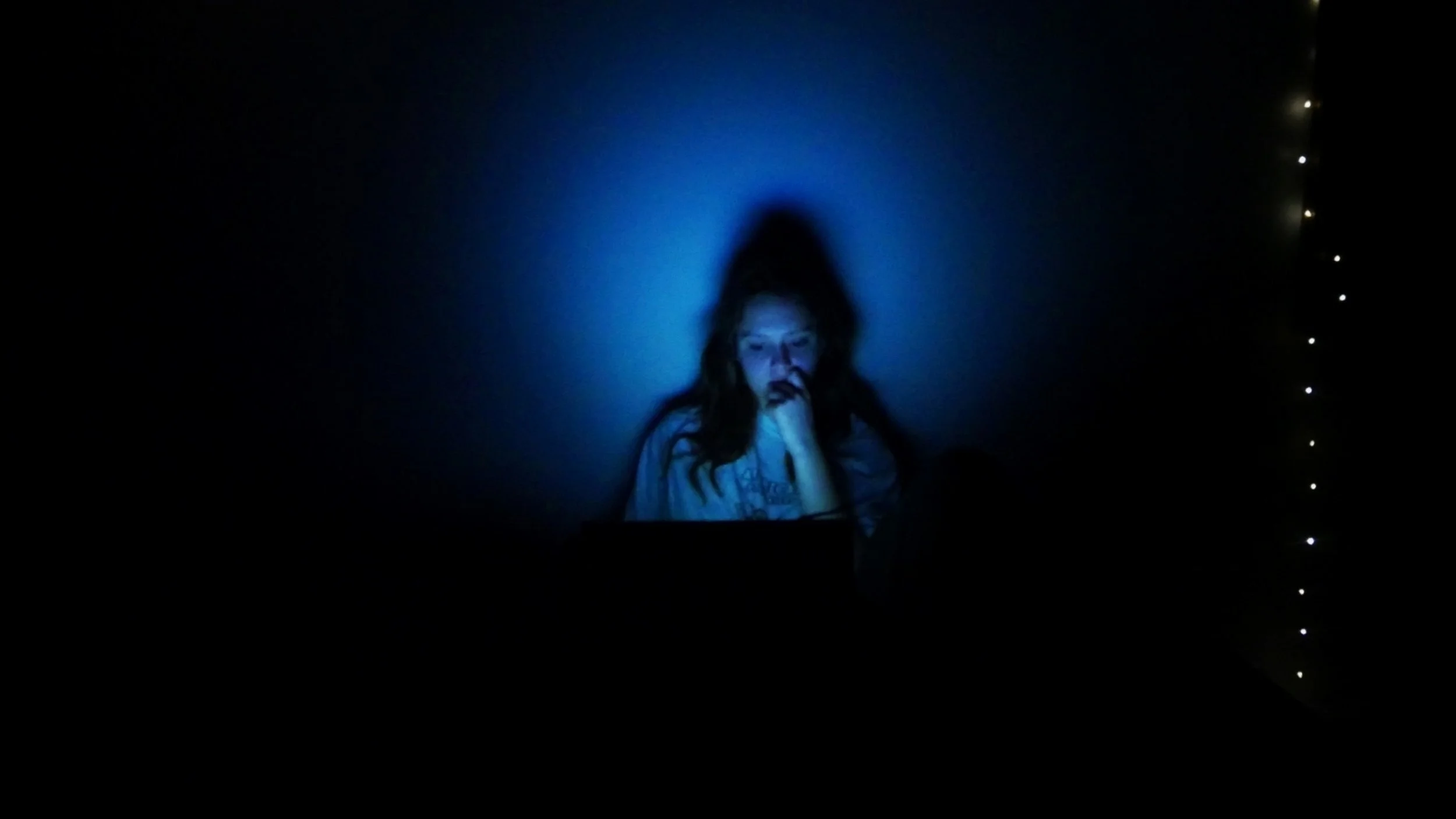 Carly Geary in a blue spotlight.
