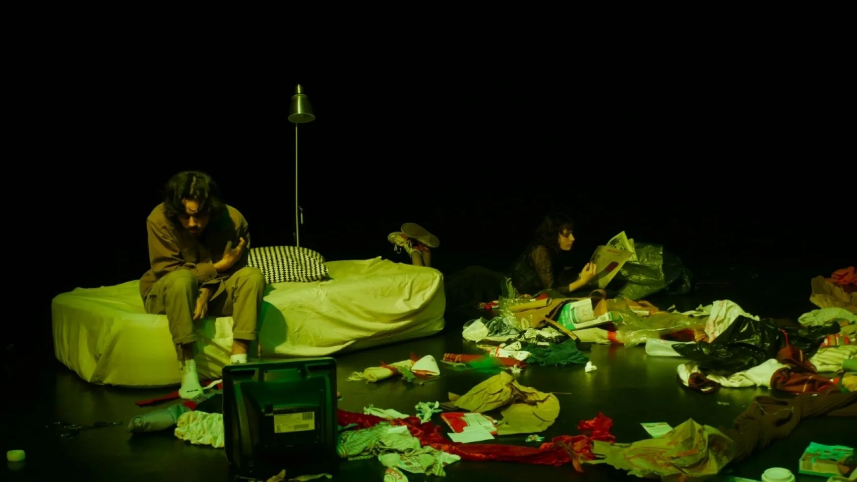 Jaycie Voller reading a paper and Aaron Sullivan scratching his arm in Jax Schuck's production of Cowboy Mouth.