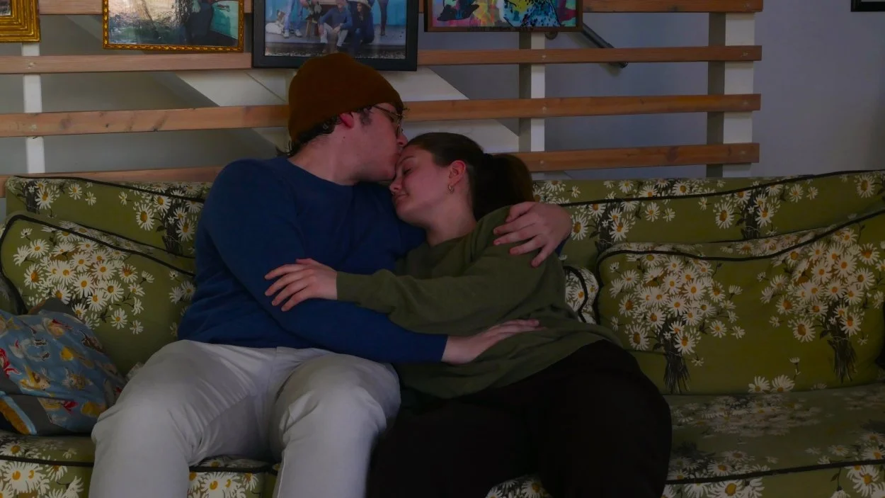 Carly Geary and Jax Schuck kissing in his original play The Loveseat. 