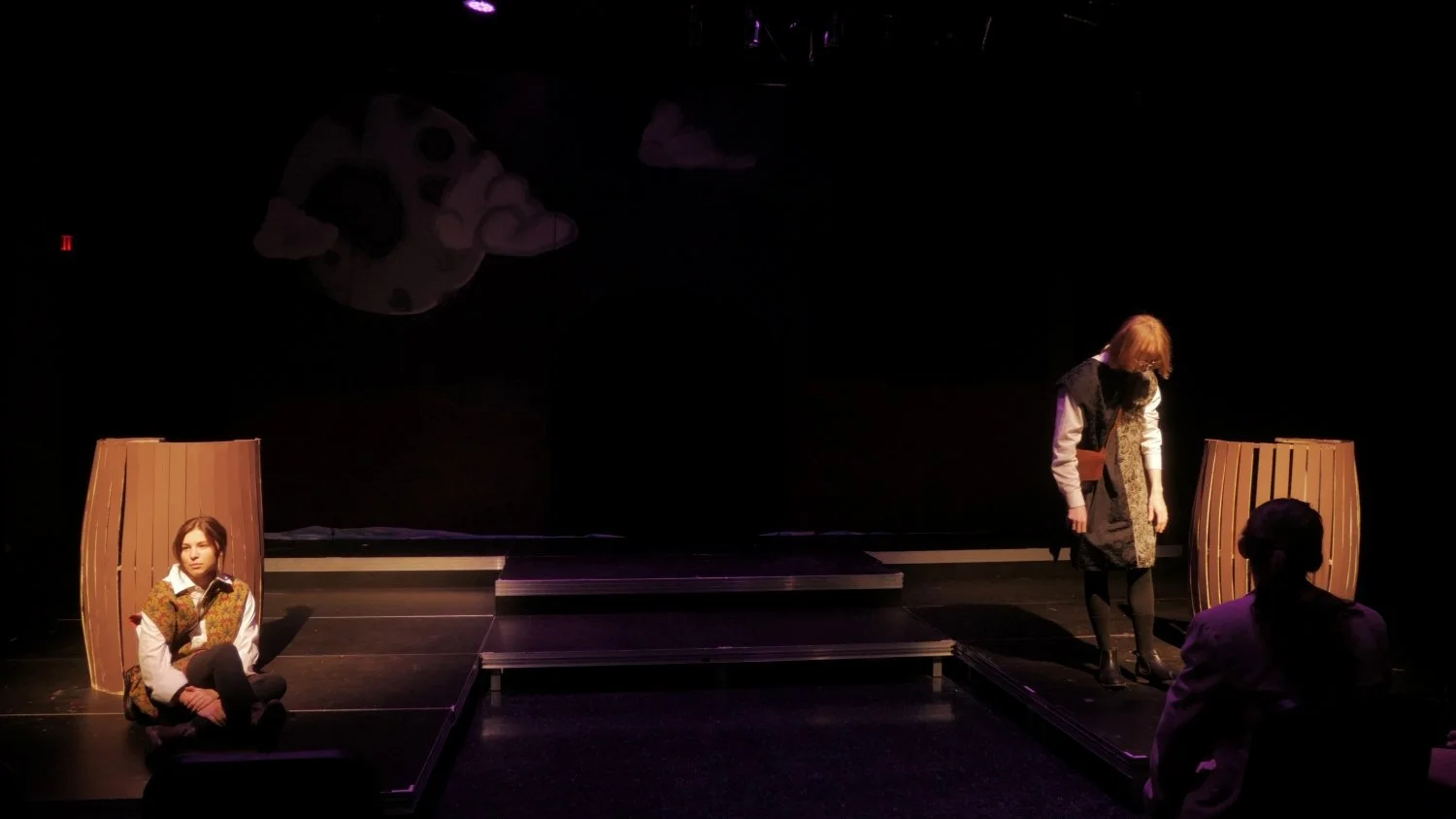 Blake Kump and Avery Barstad standing on opposite sides of the stage in Jax Schuck's production of Rosencrantz and Guildenstern Are Dead.