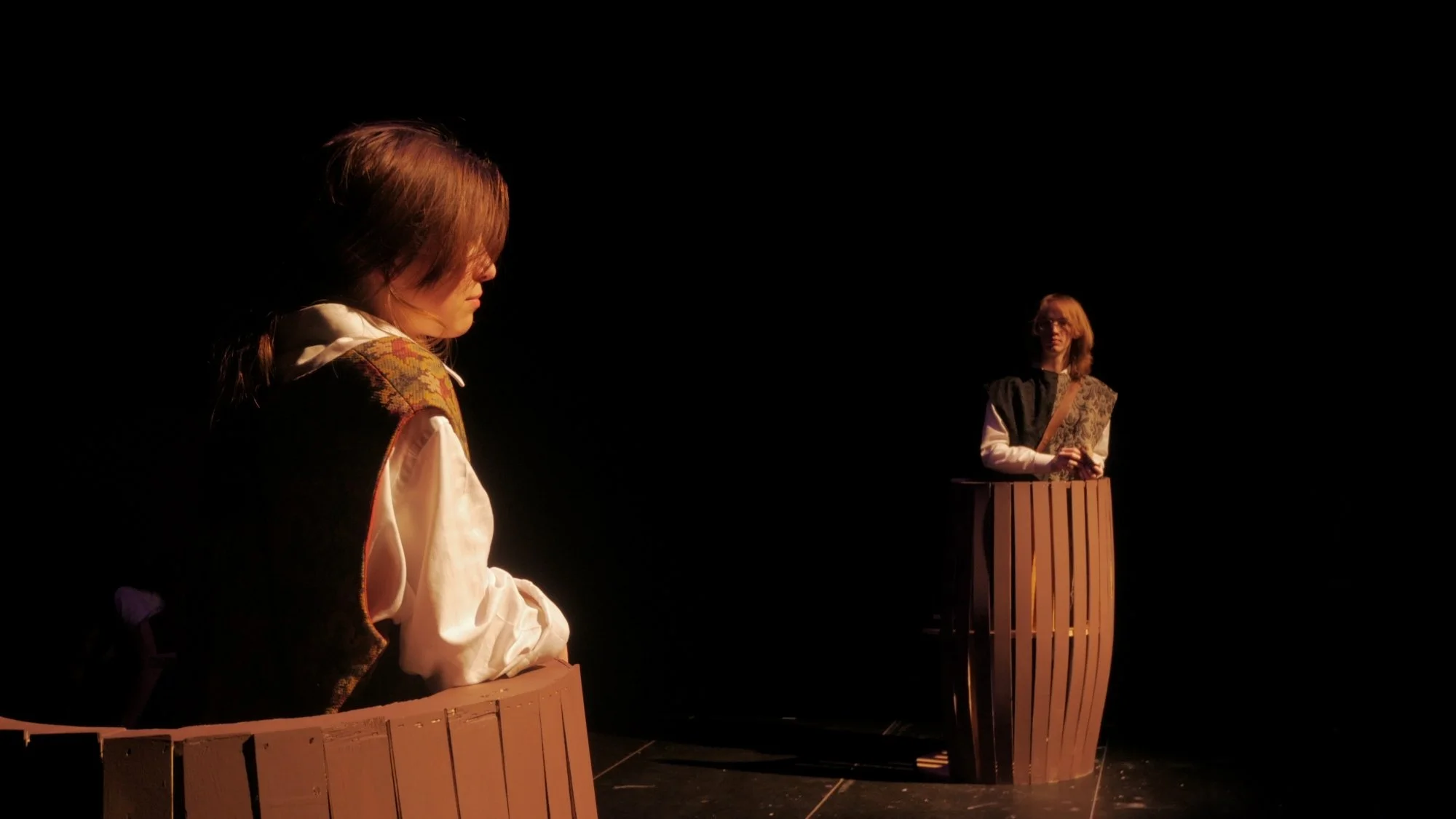 Avery Barstand and Blake Kump in buckets speak to each other in Jax Schuck's production of Rosencrantz and Guildenstern Are Dead.