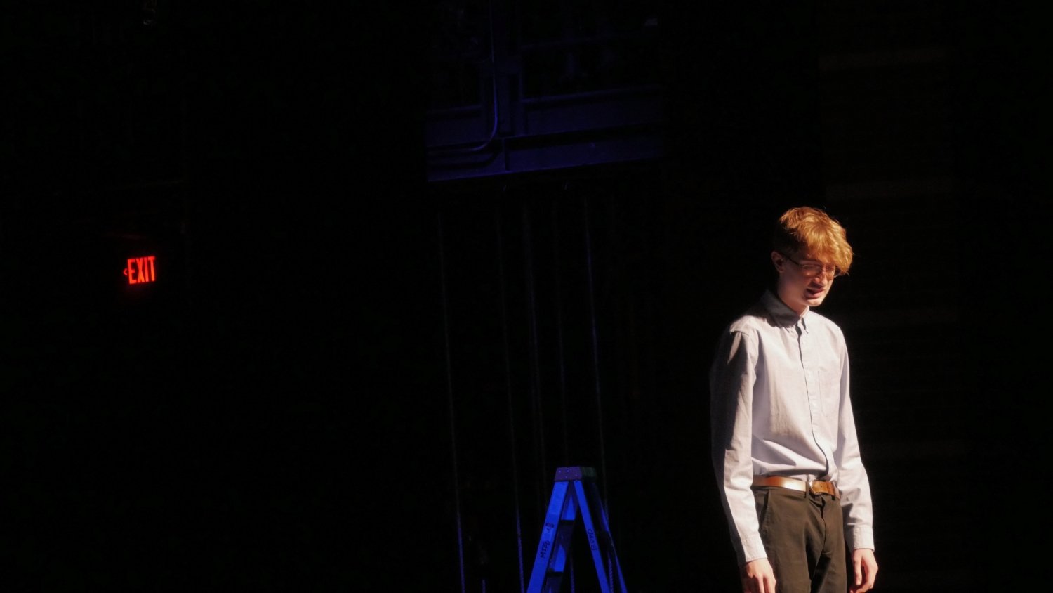 Mason Lester standing in front of a black background in Jax Schuck's Entropy.