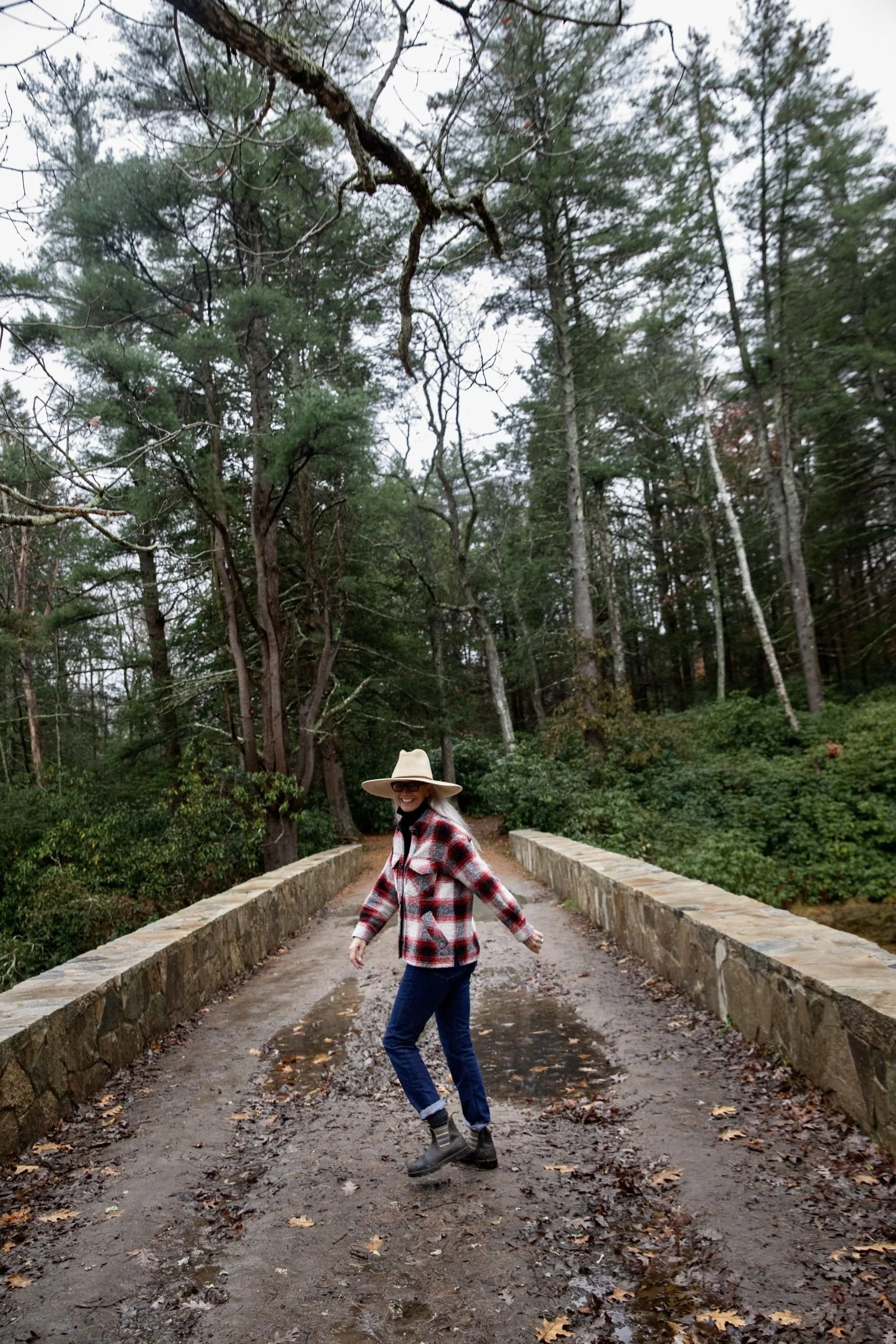 Libby DeLana crossing a bridge in the woods on one of her regular walks