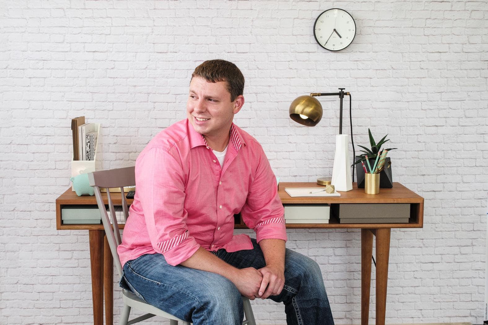 A photo of Andrew Pucci, a white male with short brown hair wearing a pink shirt and jeans.