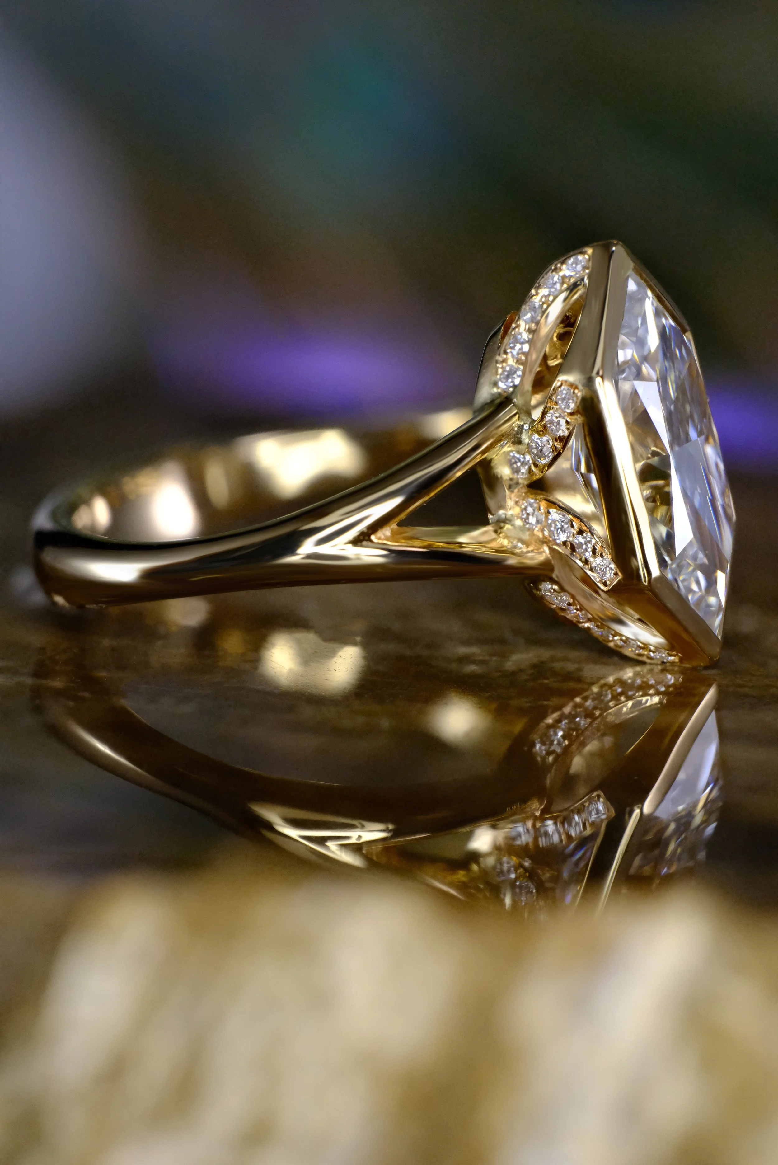 Yellow gold ring with marquise diamond, shown from the side highlighting the bezel setting and sculpted band details.