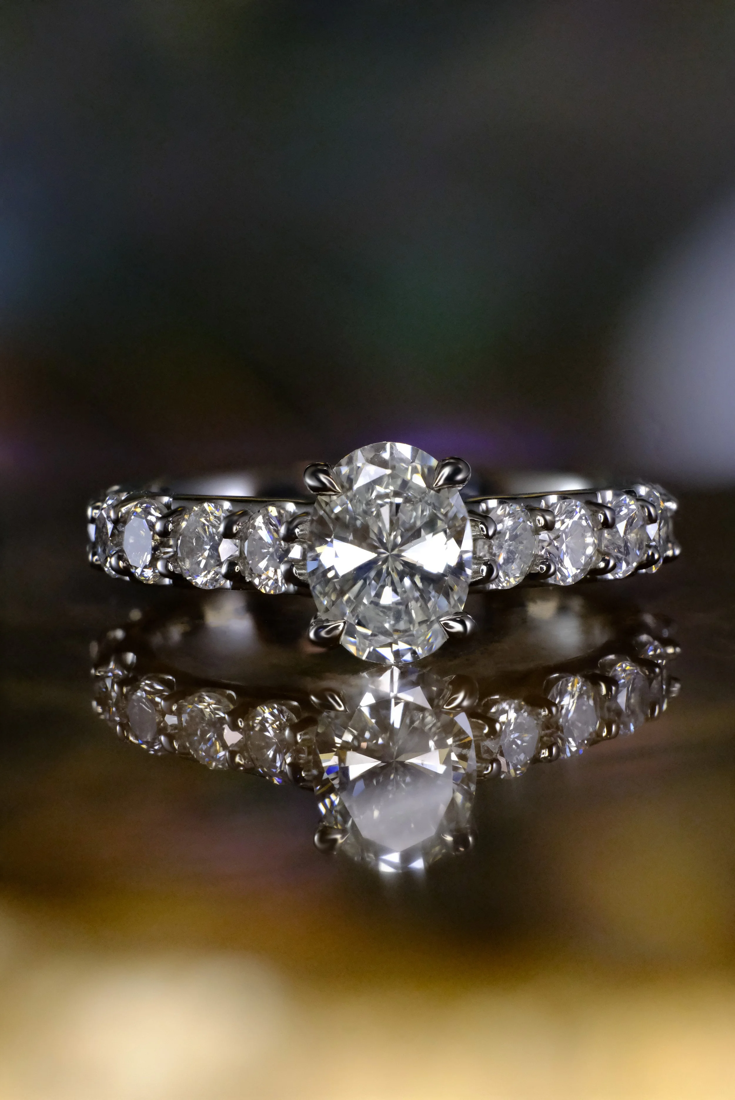 Platinum engagement ring shown head-on, featuring a round center diamond with matching round diamonds set along the band.
