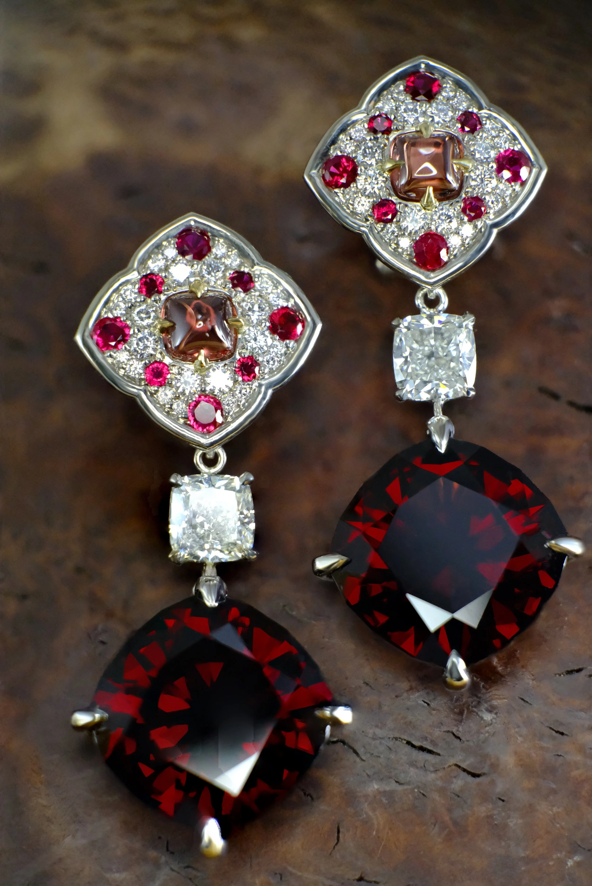 Platinum drop earrings with ruby and diamond cluster tops and square-cut dark red garnet drops.