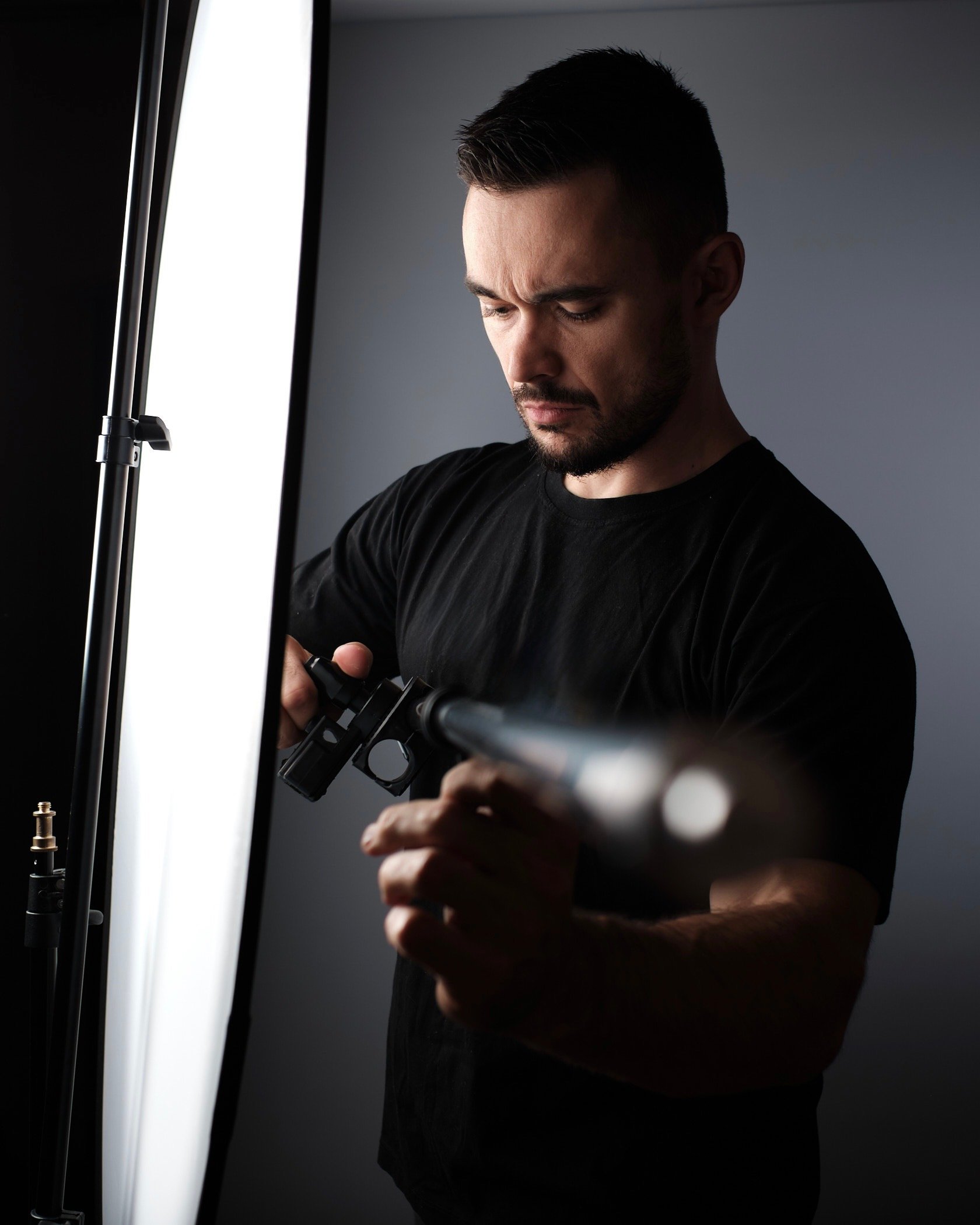 Fotograf Paweł Łappo przygotowuje lampę studyjną i modyfikator światła do sesji wizerunkowej w Trójmieście. Usługi fotograficzne Gdynia.