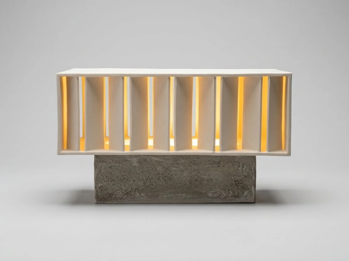 Modern decorative lamp with vertical slats on a concrete base.
