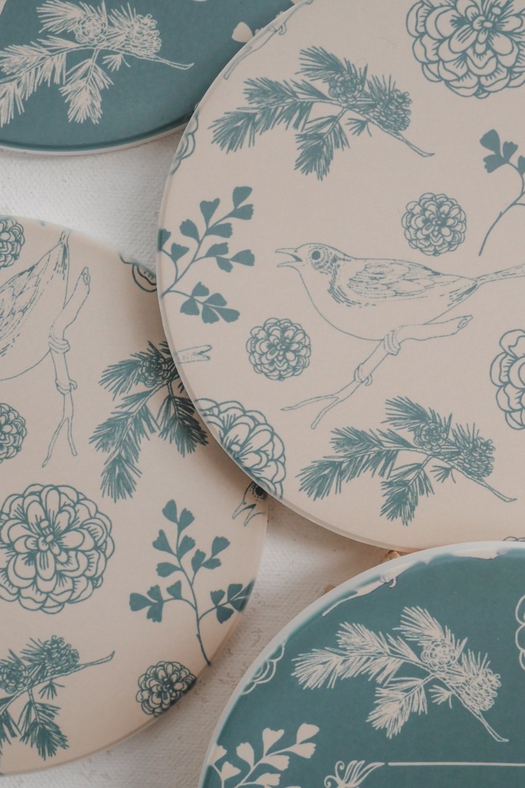 Sage and beige coasters with birds, leaves, and flowers