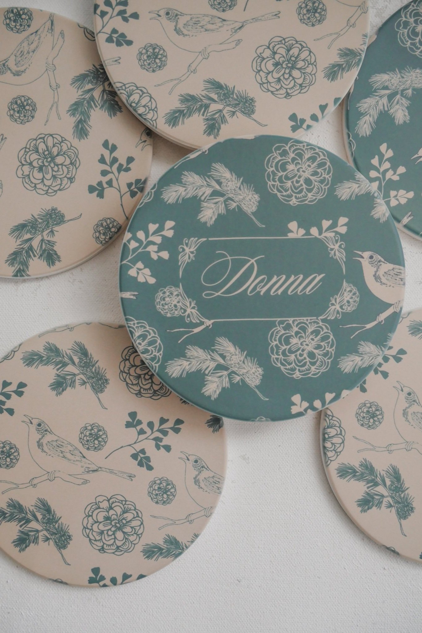 Sage and beige coasters with birds, leaves, and flowers