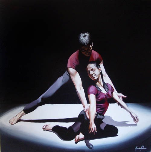 Two dancers performing on a dark stage with a spotlight. The male dancer is standing and leaning over the female dancer, who is sitting on the floor, both in dance poses.