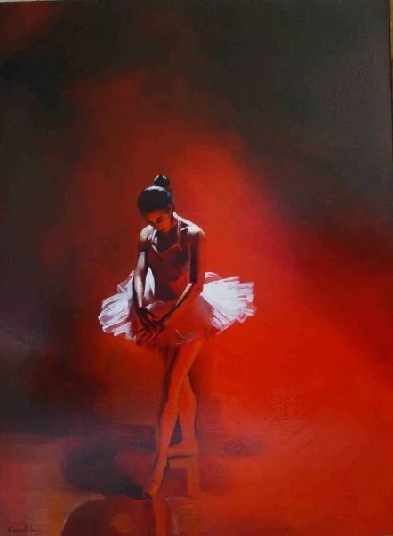 A ballerina in a pink tutu performing on stage with red lighting.