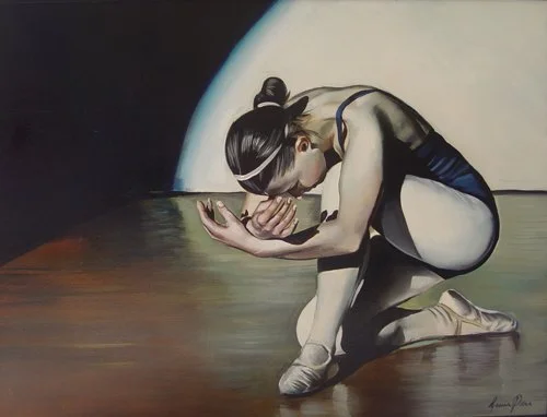 A ballet dancer in a black leotard and white tights kneeling and bowing with her head lowered and hands together, performing a dance pose on stage.