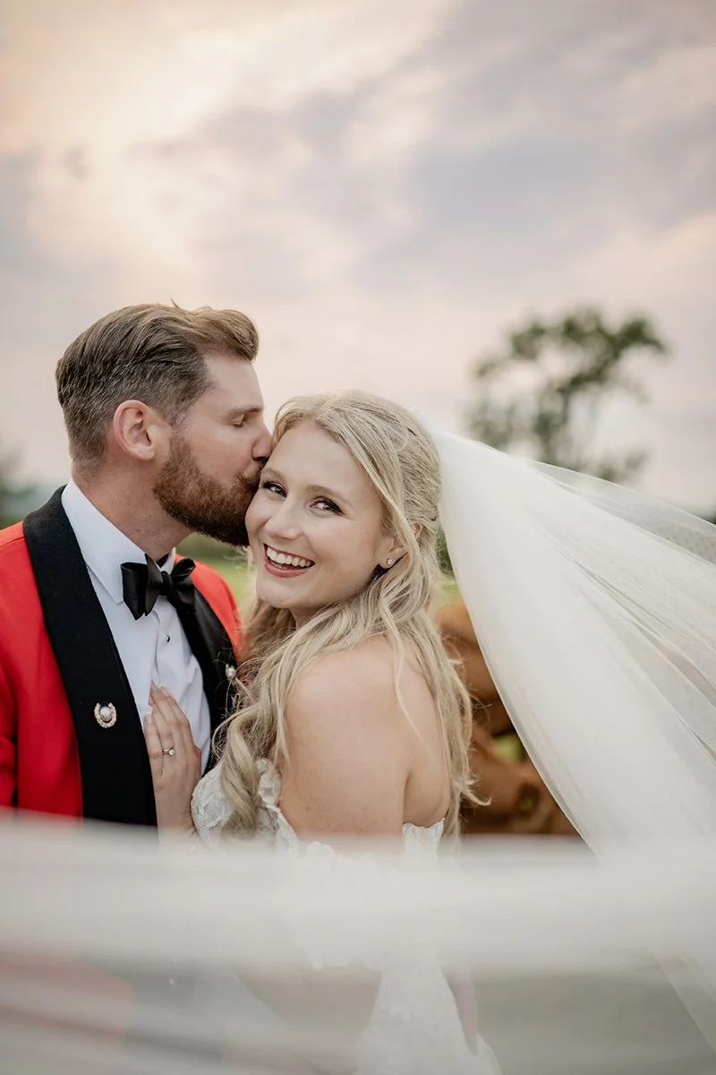 Wedding couple looking at each other holding hands in evening light. Shot by Devon Based Wedding photographer.