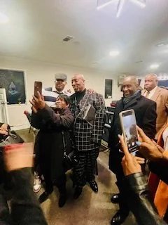 A group of people taking a selfie at an indoor gathering or event.