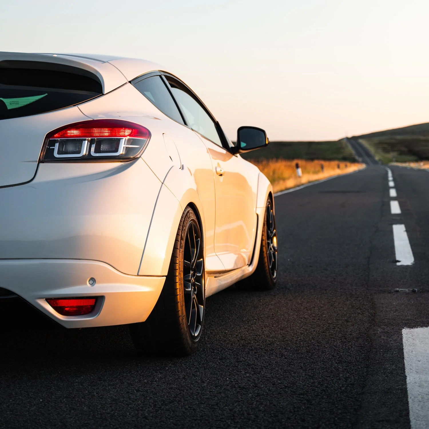 white renault megane rs on peak district road at sunset