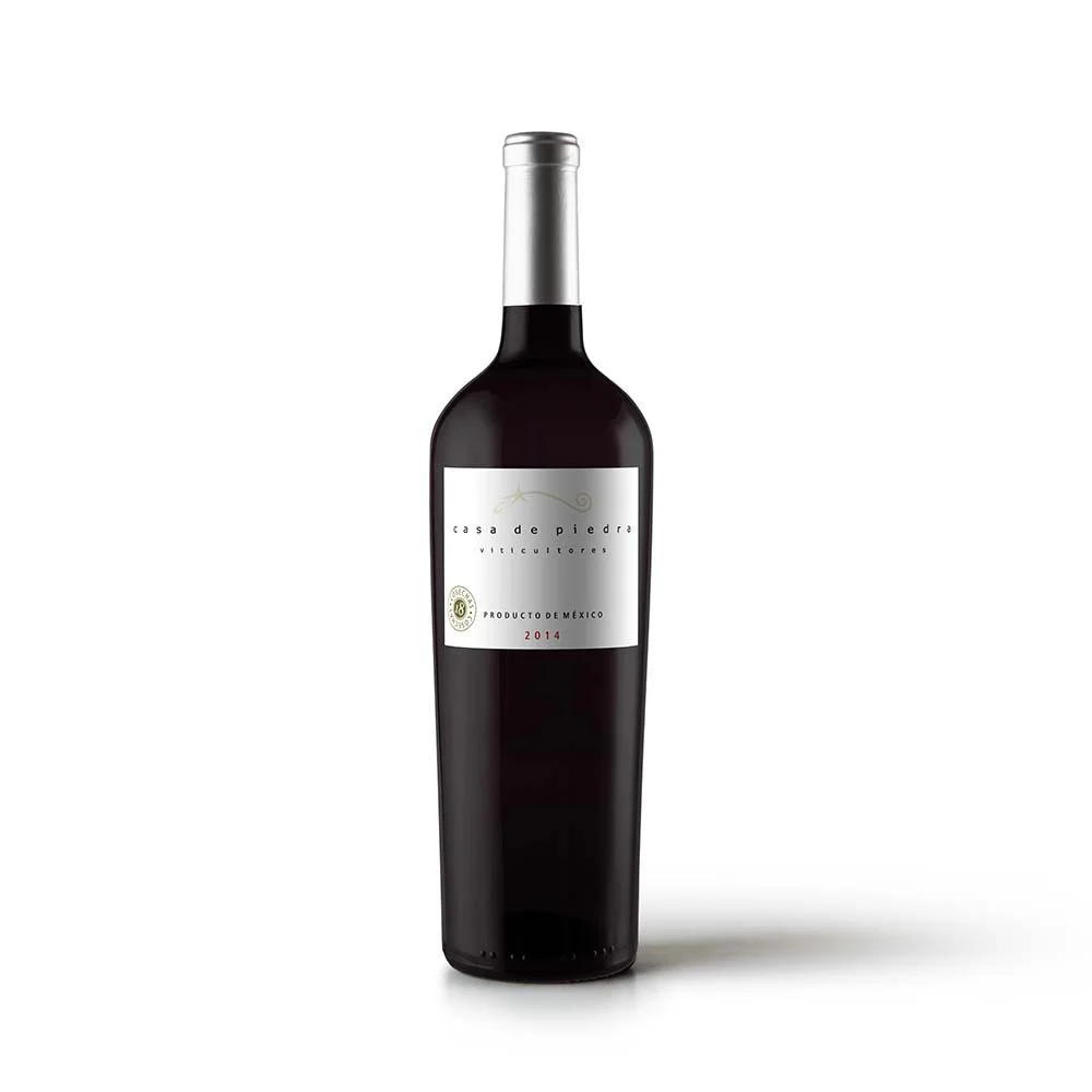 A bottle of red wine with a silver cap and a white label, indicating it is a Mexican wine from 2014.