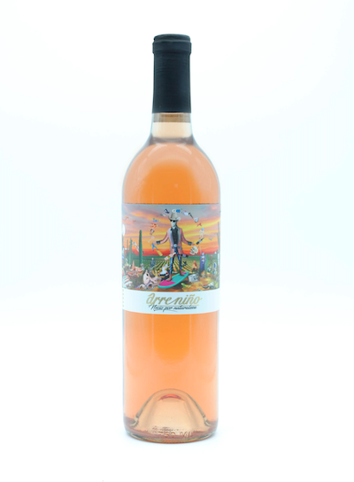 A bottle of rosé wine with a colorful label featuring a whimsical desert scene and a person with a dog, titled "arrecibo".