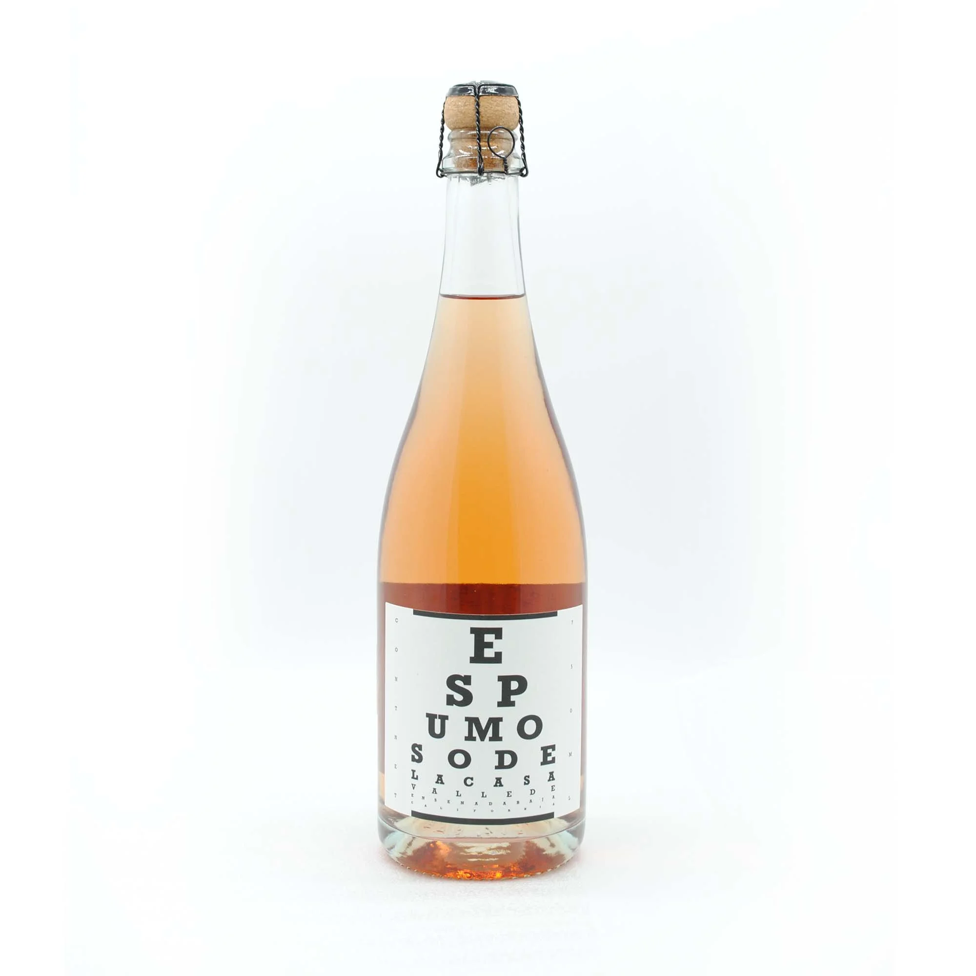 A glass bottle with a cork and wire cage contains pink champagne labeled "Es Pum Sode La Case."