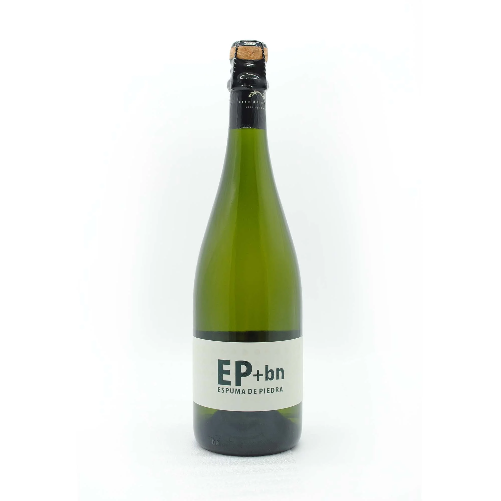 Green glass bottle of sparkling wine with cork and black foil on top, labeled 'EP+bn Espuma de Piedra'.
