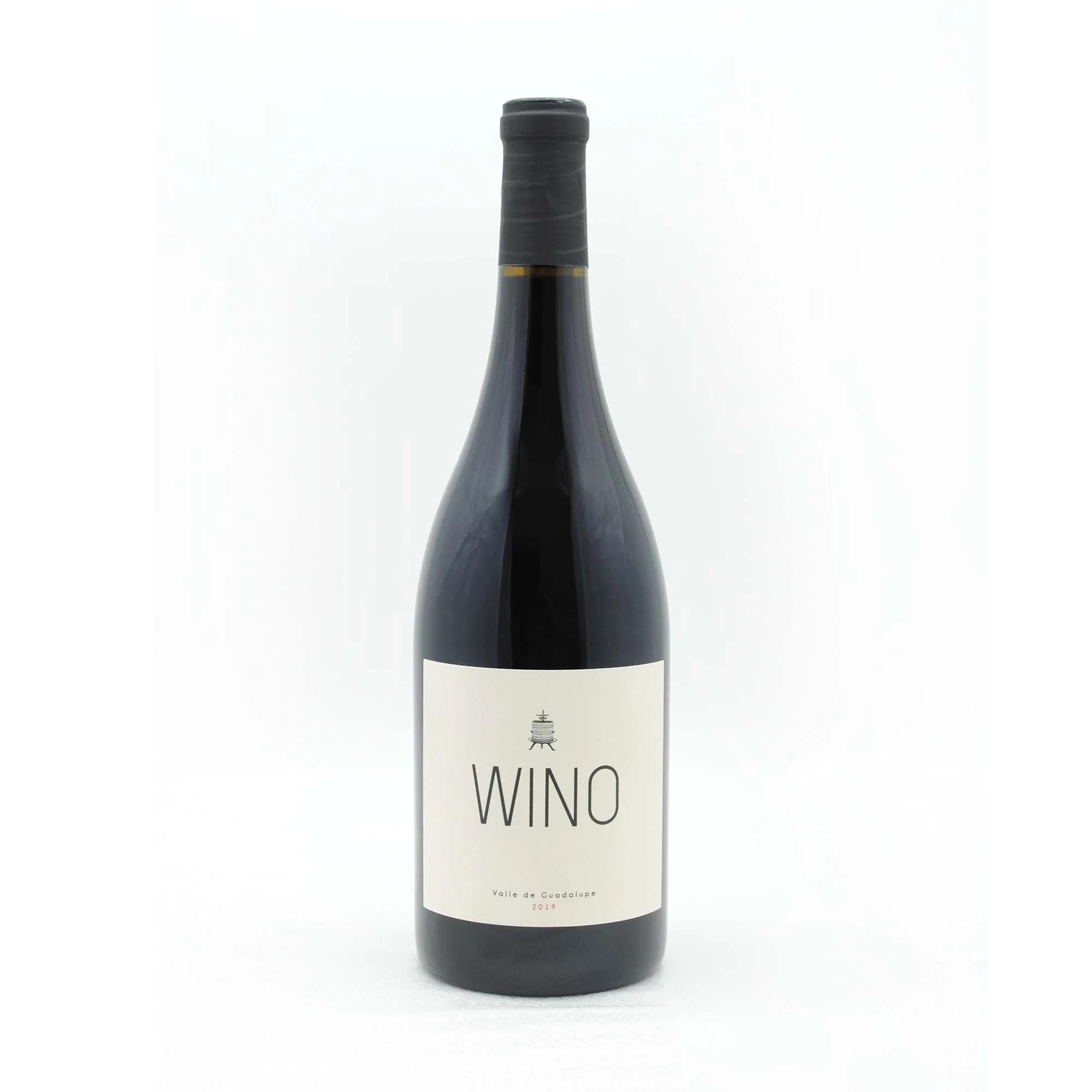 A dark glass wine bottle with a black foil capsule, featuring a minimalist white label that reads "WINO" and includes small text indicating it is from Valle de Guadalupe, vintage 2019.
